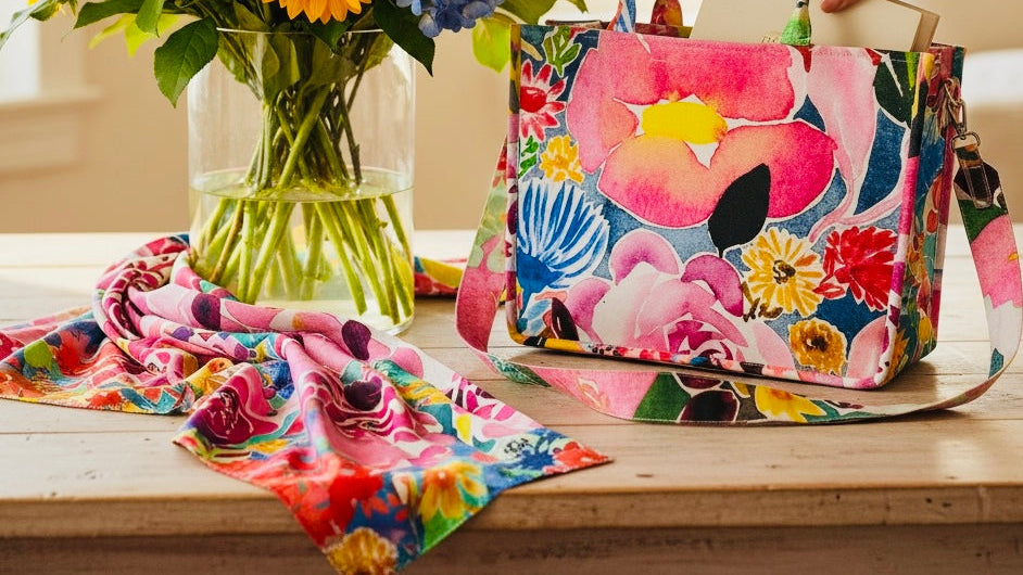 Bright pink floral wearable art handbag featuring colourful blooms and artistic floral designs