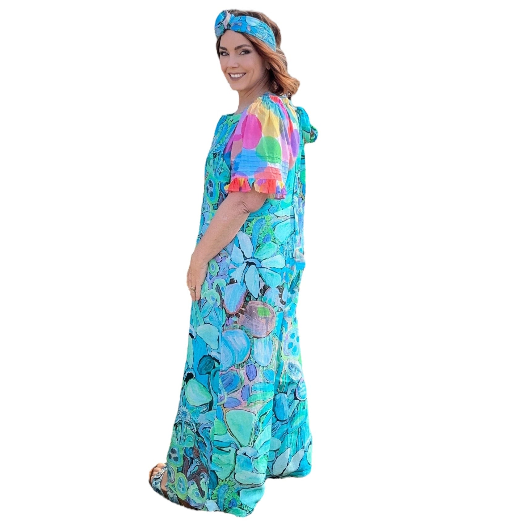 Woman wearing a bright blue jumpsuit in floral artwork