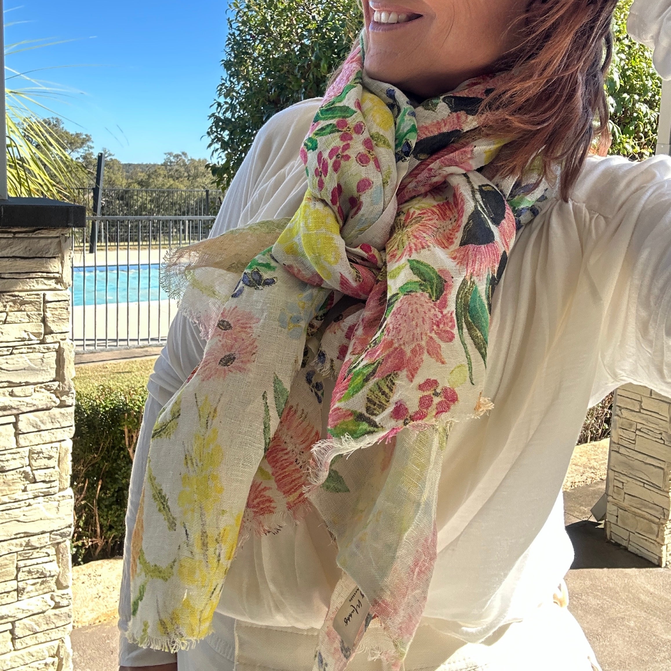 Lightweight wearable art linen scarf featuring soft wildflower-inspired artwork in pastel tones