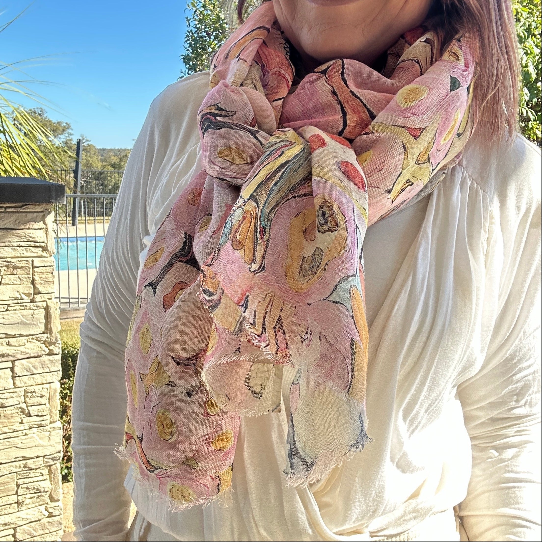 Soft pink floral wearable art linen scarf styled as an elegant lightweight fashion accessory