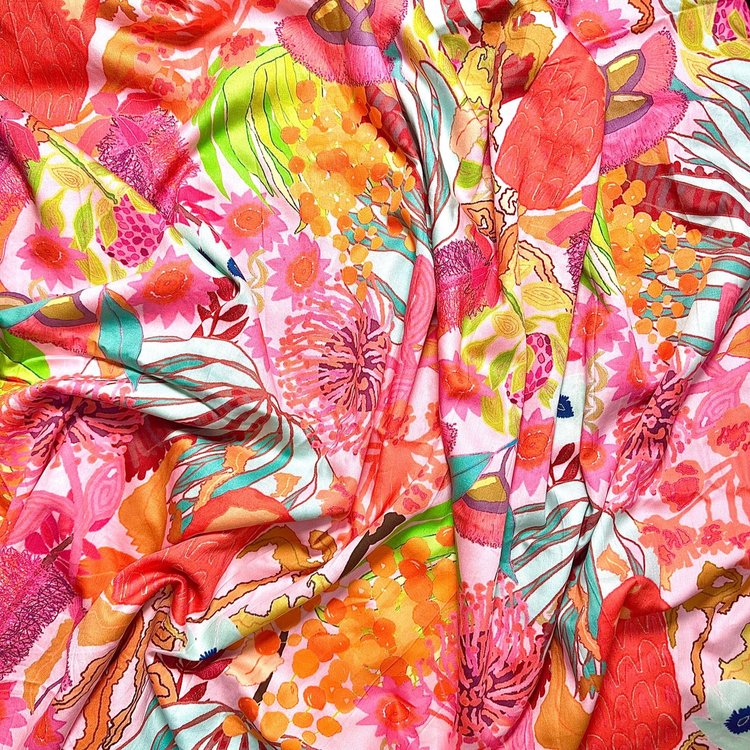 A vibrant piece of fabric featuring a floral and bushfire-related art print with predominantly pink and orange colors.