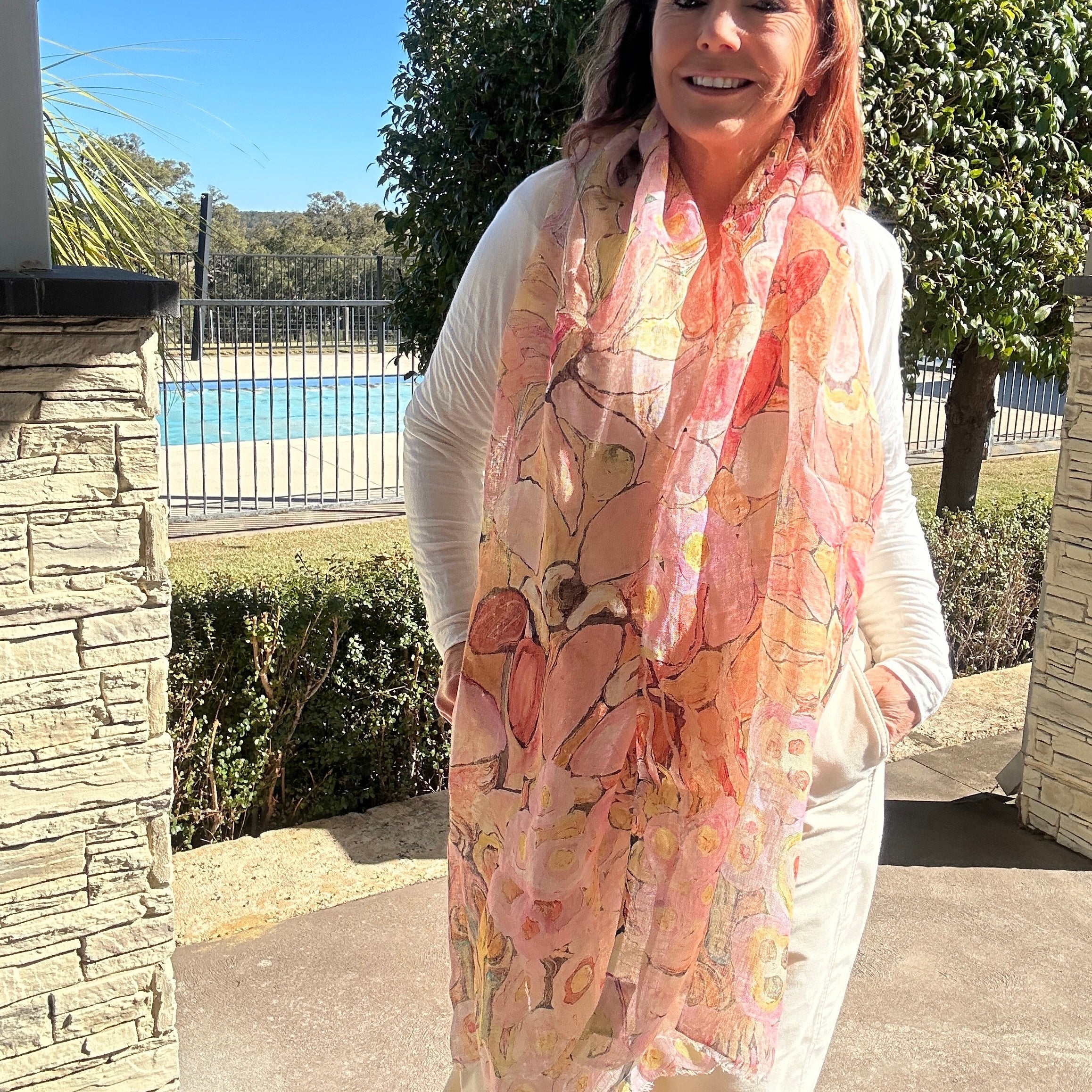 Soft peachy pink floral wearable art linen scarf styled as an elegant lightweight fashion accessory